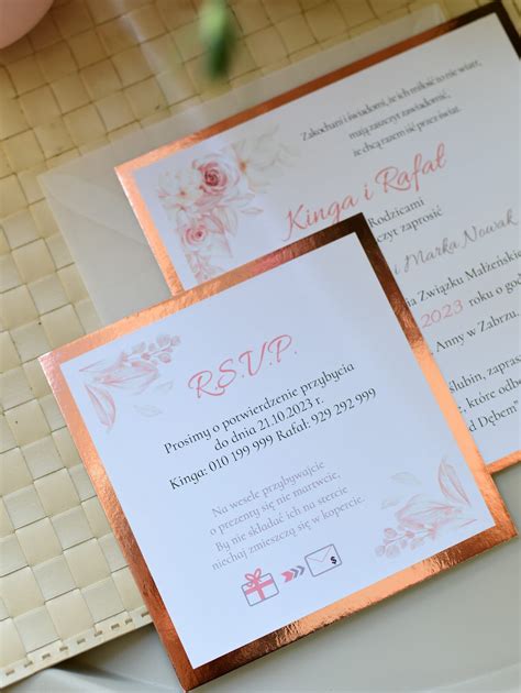 Zbliżenie na teksturę perłowego papieru i atłasowej wstążki na zaproszeniu.