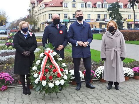 zdjęcie przedstawiające kwiaty złożone pod pomnikiem przez przedstawicieli władz