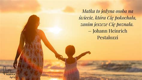 Zdjęcie przedstawiające matkę trzymającą na rękach wnuczkę, z córką stojącą obok z uśmiechem.