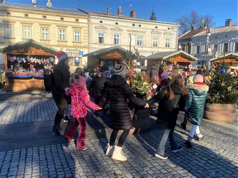 Widok ogólny na kamieniczkę-lampion w świątecznych barwach, z zaznaczonymi detalami imitującymi cegłę i dachówki, ozdobioną śniegiem i brokatem.