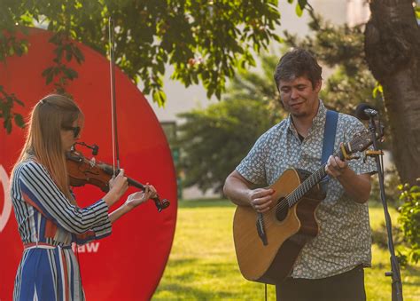 Para muzyków (gitarzysta i skrzypaczka) podczas występu