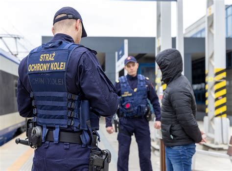 Kadr z filmu przedstawiający mężczyznę w pociągu, otoczonego przez funkcjonariuszy policji.