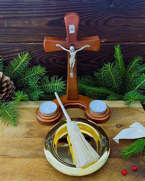 aranżacja stołu do błogosławieństwa z elementami religijnymi: świece, Biblia, woda święcona, kropidło