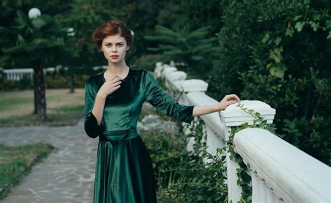 Kobieta w eleganckiej sukience w kolorze butelkowej zieleni, podkreślającej jej styl