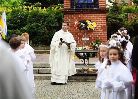zdjęcie dzieci przygotowujących się do pierwszej komunii świętej, w tle kościół