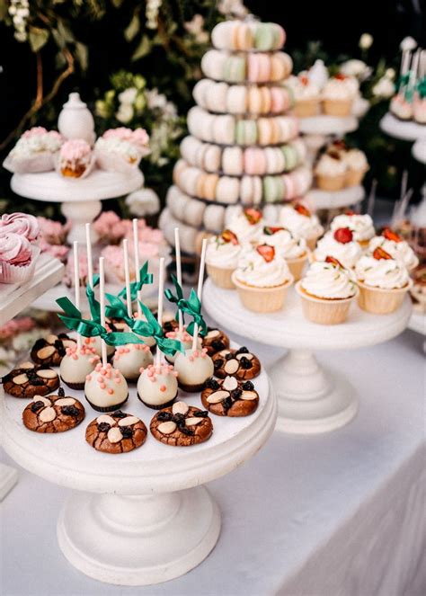 Różnorodne babeczki, makaroniki i cake popsy na paterze