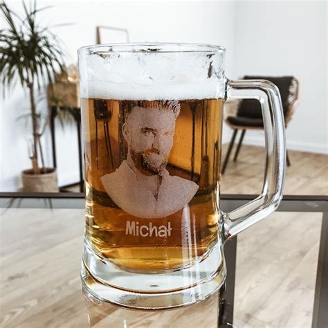 Kolekcja personalizowanych gadżetów dla mężczyzn: kompas, zapalniczka, kufle do piwa i skrzynki z grawerem.