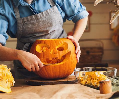 Zdjęcie rodziny wspólnie rzeźbiącej dynię na Halloween