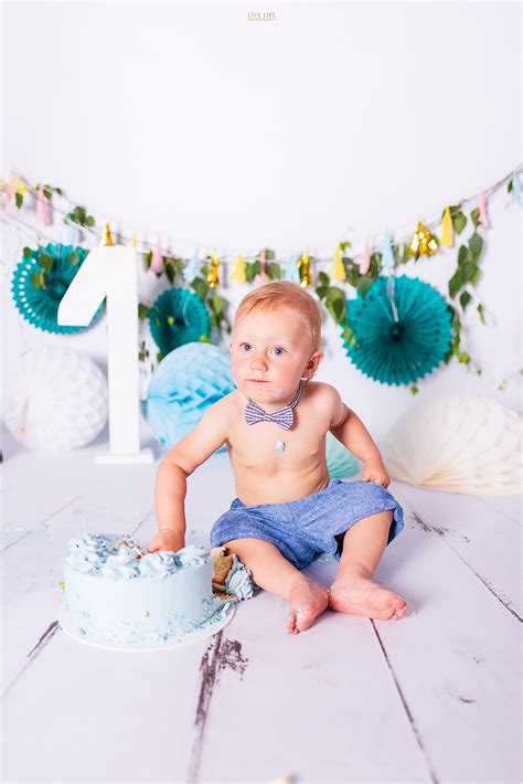 Dziecko z umazaną czekoladą buzią, jedzące tort podczas sesji smash cake