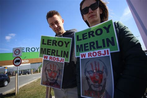 Zdjęcie z akcji protestacyjnej pod sklepem Leroy Merlin, z transparentami wyrażającymi sprzeciw wobec działań firmy.