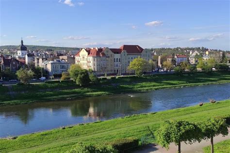 Panorama malowniczego krajobrazu województwa kujawsko-pomorskiego z widokiem na rzekę i zabytkową architekturę.