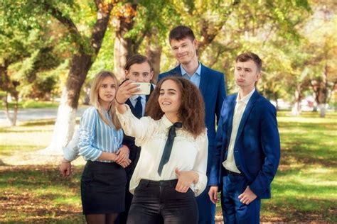 Grupa elegancko ubranych uczniów podczas balu studniówkowego