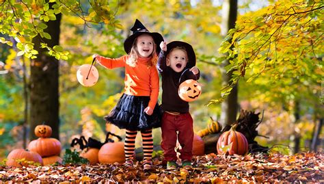 Dzieci w kolorowych strojach świętują Halloween.