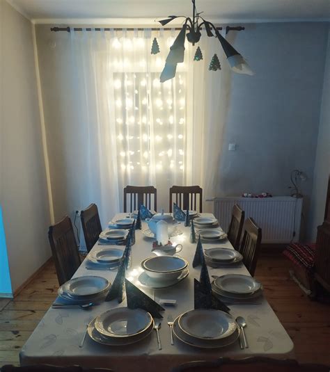 Stół udekorowany lnianym obrusem, ceramicznymi talerzami i świecami